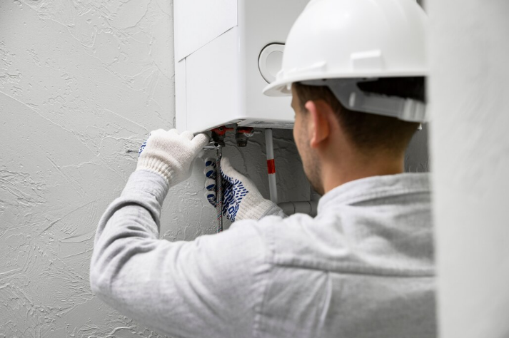 Professional technician installing new LPG boiler grant eligible heating system in residential home