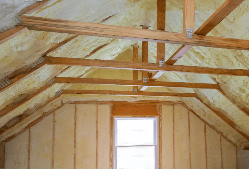 Loft insulation grant eligible attic space with exposed wooden beams and insulation materials