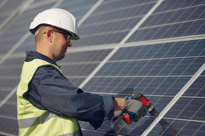 Solar panel technician installing photovoltaic panels for solar energy grant program