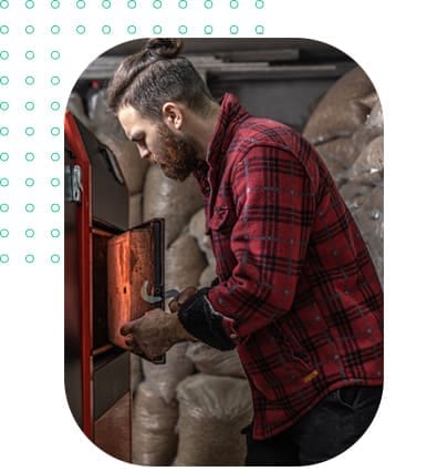 Heating technician servicing biomass boiler showing the types of boilers available under government grant programs